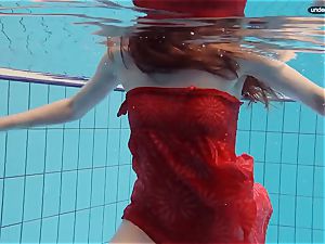 crimson dressed teen swimming with her eyes opened